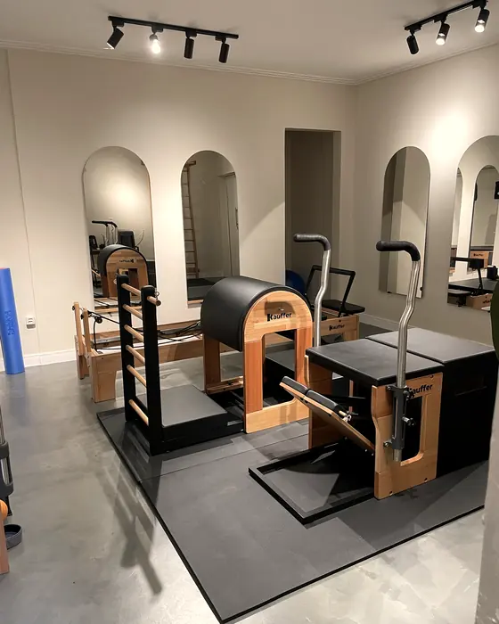 Aparelhos de Pilates e espelhos em arco no estúdio da Clínica São Francisco